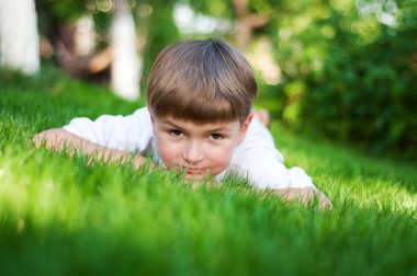 Yeşil çimenlerin üzerinde genç çocuk