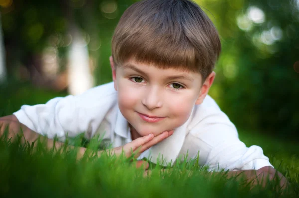 Jeune garçon sur l'herbe verte — Photo