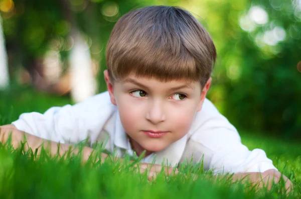 Yeşil çimenlerin üzerinde genç çocuk — Stok fotoğraf