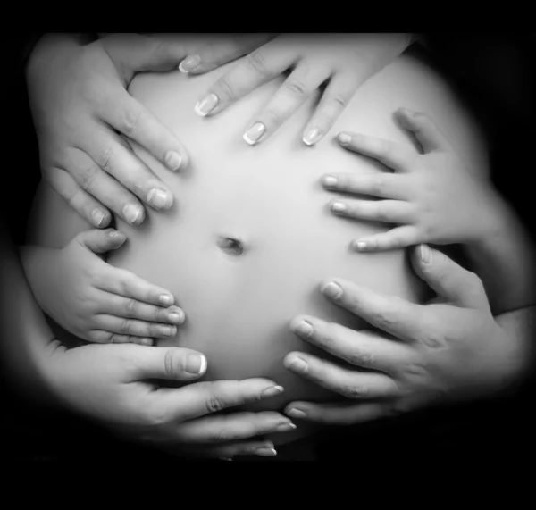 Manos y vientre: vientre de mujer embarazada cogido de la mano de madre, padre e hijo —  Fotos de Stock