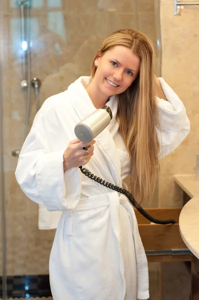 Mujer con pelo largo sosteniendo secador de pelo — Foto de Stock