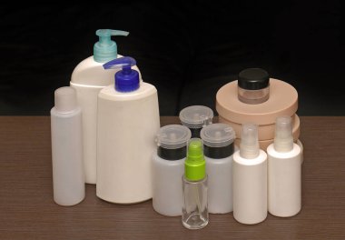 Kapalı plastik kozmetik ve güzellik ürünleri şişeleri ahşap rafta tuvalet malzemeleri