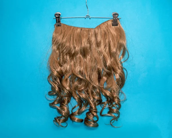 ダークブロンドカール髪拡張子ウィッグ上のシルバーハンガー — ストック写真