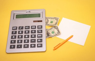 Notlar ve Amerikan dolarları için büyük elektronik hesap makinesi ve boş kağıt.