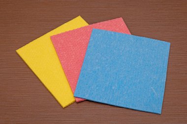 Ahşap kahverengi masa üzerinde bir yığın temiz renkli sünger bezi.