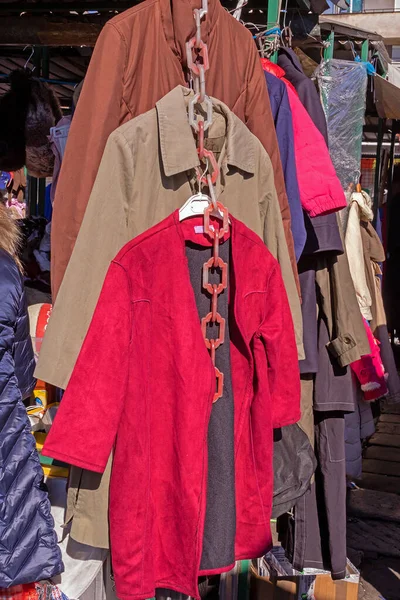 地元の市場の屋台で販売される女性のジャケットやコートの服 — ストック写真