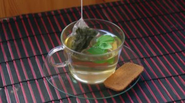 Çay poşetini şeffaf cam çay bardağının içine batırmak.