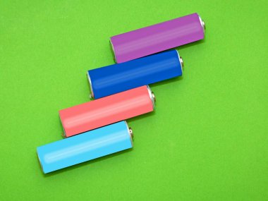 Yeşil arka planda yeniden şarj edilebilir renkli lityum piller