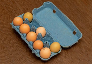 Açık karton kutunun içinde çiğ organik tavuk yumurtası.