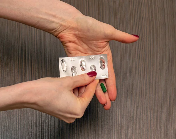 銀製ブリスターパッケージから処方薬を服用している女性の手 — ストック写真