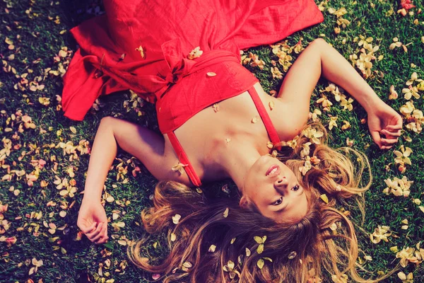 Красива молода жінка лежить у квітах — стокове фото