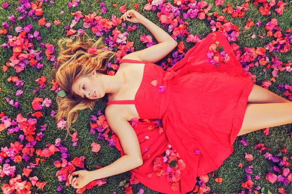 Piękna młoda kobieta leżący w kwiaty — Zdjęcie stockowe
