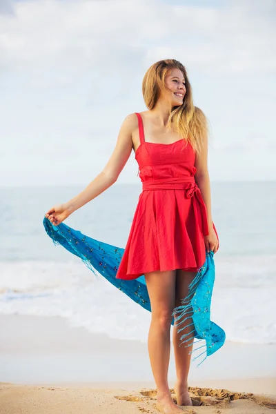Bella ragazza in abito rosso sulla spiaggia. Viaggi e vacanze . — Foto Stock