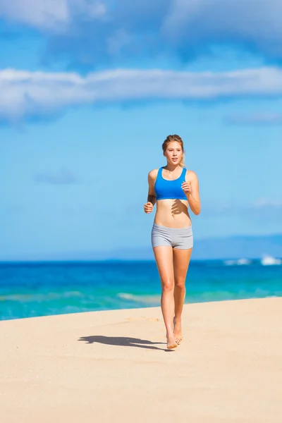 Schöne athletische Frau läuft am Strand — Stockfoto