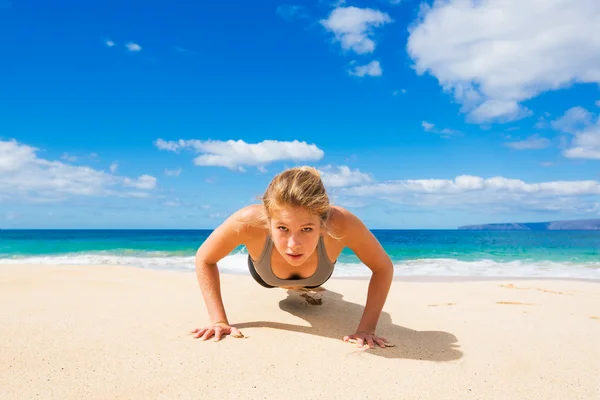 Mooie sportieve vrouw op het strand — Stockfoto