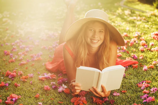 Young Woman Reading Book Outside Stock Photo