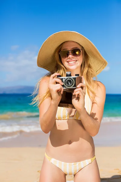 Mulher bonita na praia com câmera — Fotografia de Stock