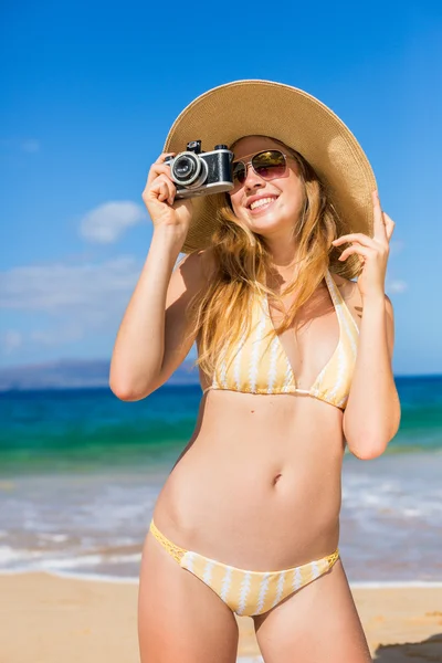 Bella donna in spiaggia con fotocamera — Foto Stock