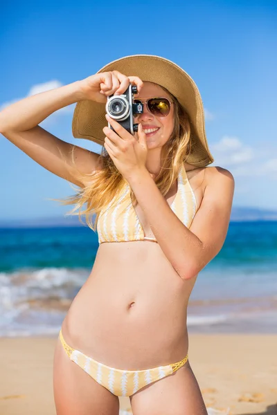 Mulher bonita na praia com câmera — Fotografia de Stock