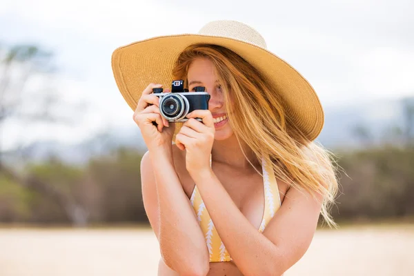 Mulher bonita na praia com câmera — Fotografia de Stock