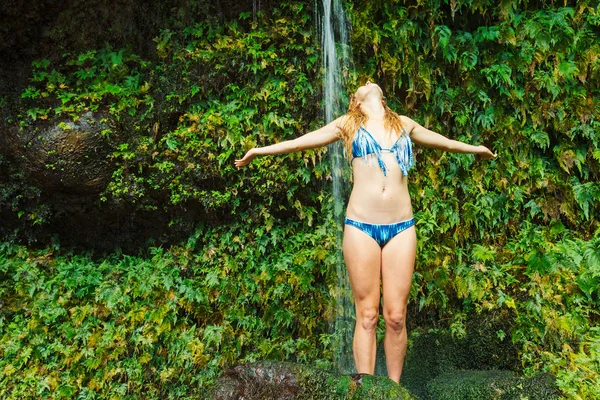 Frau praktiziert Yoga in der Nähe tropischer Wasserfälle — Stockfoto