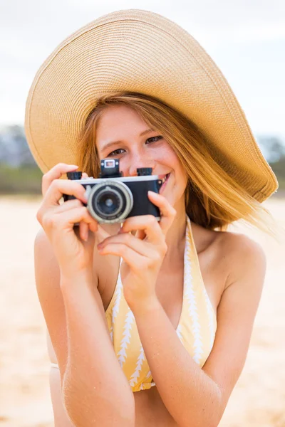 Όμορφη γυναίκα στην παραλία με κάμερα — Φωτογραφία Αρχείου