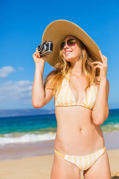 美丽的女人在用相机海滩 免版税图库图片