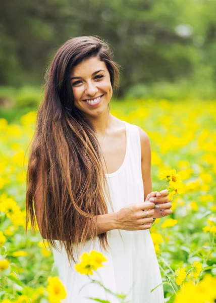 Kvinna i fält av blommor — Stockfoto