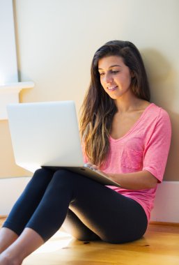 dizüstü bilgisayar kullanan mutlu bir genç kadın