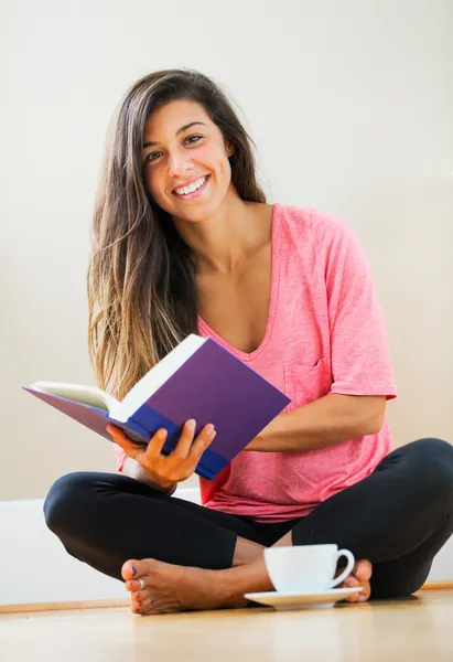 Glückliche junge Frau liest ein Buch — Stockfoto