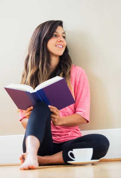 Glückliche junge Frau liest ein Buch — Stockfoto