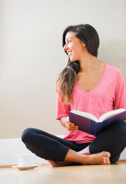 Glückliche junge Frau liest ein Buch — Stockfoto