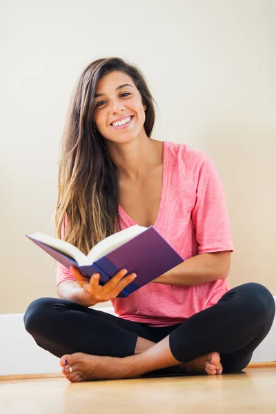 Счастливая молодая женщина, читающая книгу — стоковое фото