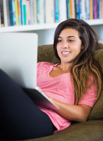 Glad ung kvinna som använder en bärbar dator — Stockfoto
