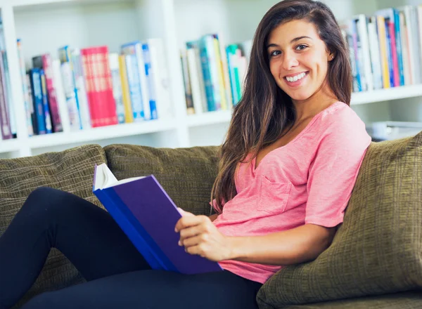 Glückliche junge Frau liest ein Buch — Stockfoto