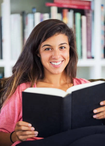 Glückliche junge Frau liest ein Buch — Stockfoto