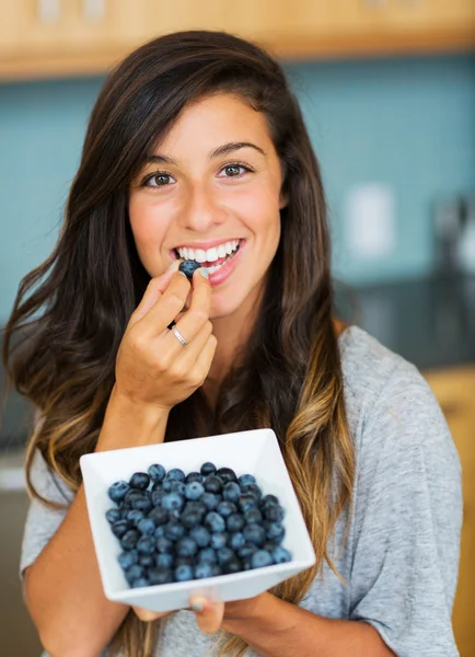 Beautiful woman eating blueberries — Stock Photo, Image
