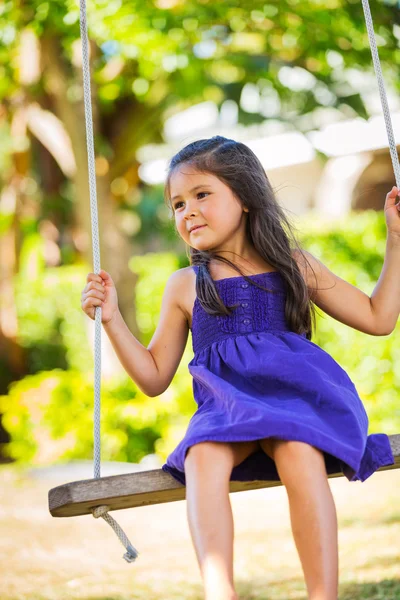 Flicka som leker på swing set — Stockfoto