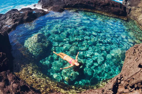 Mujer flotando en piscina natural — Foto de Stock