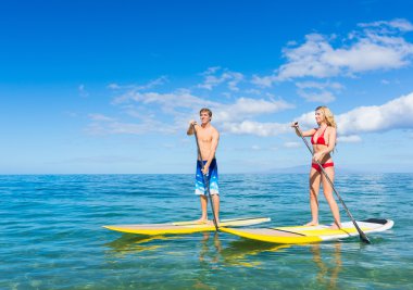 Couple Stand Up Paddle Surfing In Hawaii clipart