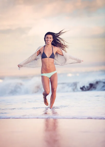 Жінка ходить на пляжі на заході сонця — стокове фото