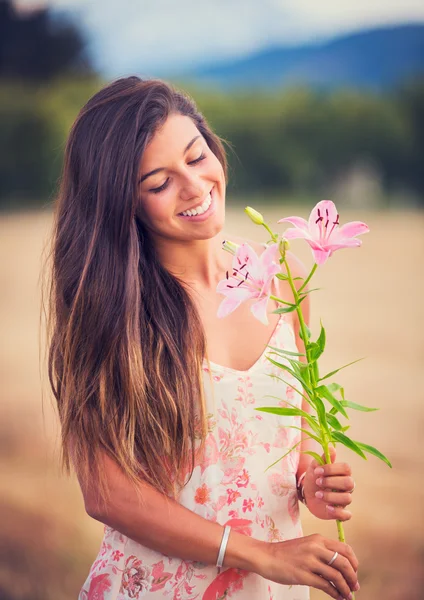 Frau riecht Blumen in der Natur — Stockfoto