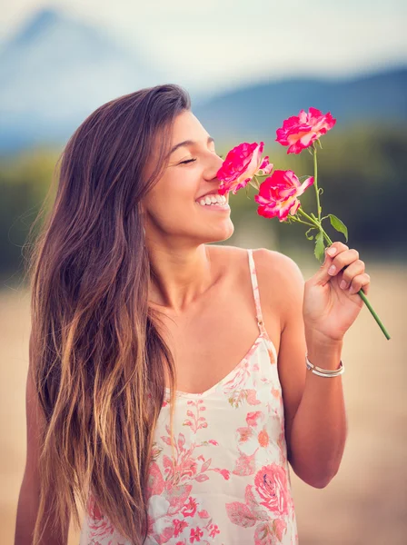 Женщина нюхает цветы в природе — стоковое фото