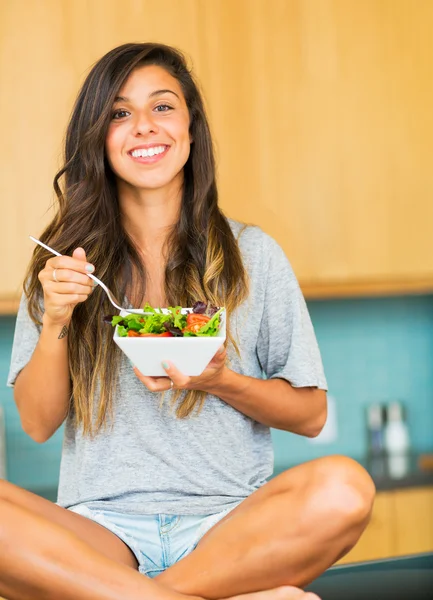 Frumoasă femeie tânără care mănâncă un castron de salată organică sănătoasă — Fotografie, imagine de stoc