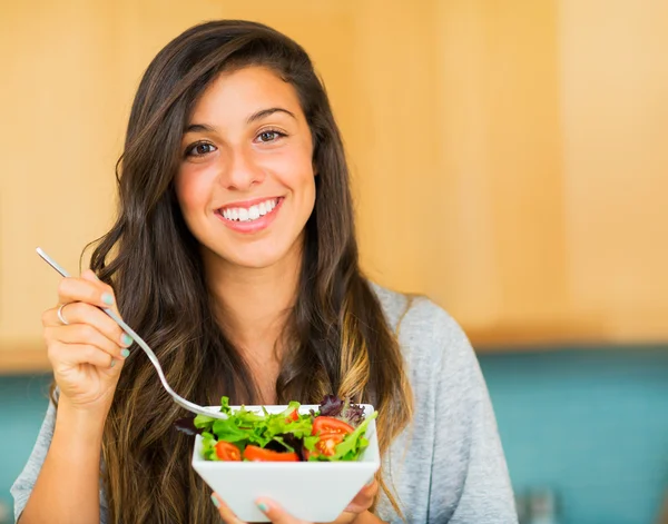 Bella giovane donna mangiare una ciotola di sana insalata biologica — Foto Stock