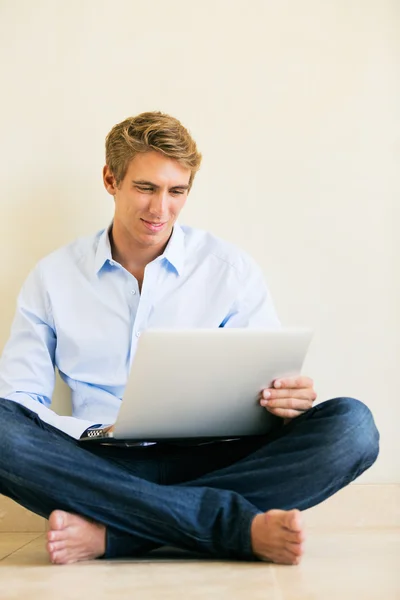 Jeune homme travaillant sur ordinateur portable à la maison — Photo