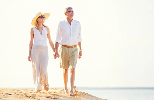 Mellersta åldern par njuter av promenad på stranden — Stockfoto