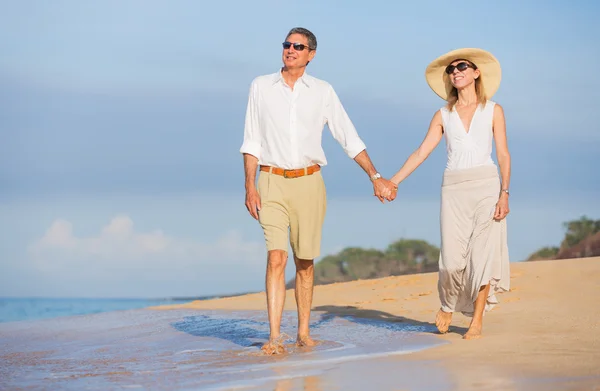 Pareja de mediana edad disfrutando de un paseo por la playa — Foto de Stock