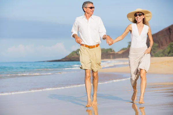 Casal de meia-idade desfrutando de caminhada na praia — Fotografia de Stock