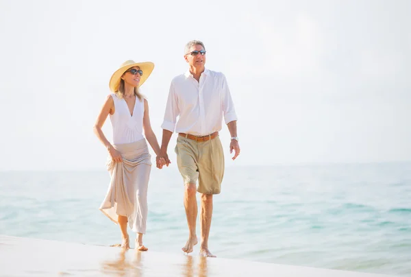 Coppia di mezza età che gode di passeggiata sulla spiaggia — Foto Stock